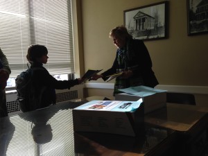 Handing letters written in class to the Senator.